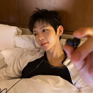 SHOTARO wearing earphones in bed